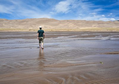 2022-06-04 USA Colorado Great Sand Dunes National Park creek man walking national park dunes sand water river