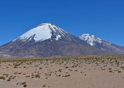 2022-11-14 Südamerika Chile chilenisches Altiplano Hochebene Hochplateau Hochland Anden Lauca Nationalpark Lago Chungara See Berge Vulkan Schnee Parinacota Pomerape Wüste Landschaft