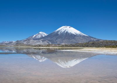 2022-11-14 South America Chile chilean Altiplano high plain plateau Andean Plateau Andes Mountains Andean Mountain Range Lauca National Park Laguna lagoon Cotacotani water different color colour islands mountains volcano landscape Pomerape Perinacota snow hike reflections in the water